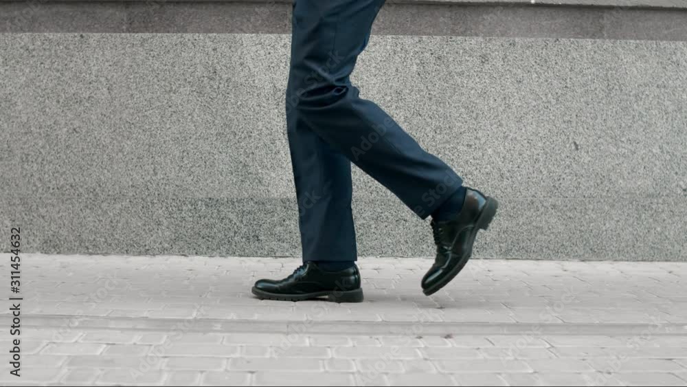 Business man legs walking in black shoes. Closeup black shoes walking outdoor Business man legs walking in black shoes. Closeup black shoes walking outdoor