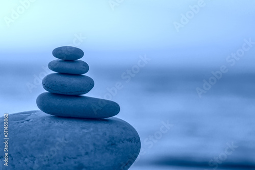 Perfect balance of stack of pebbles at seaside towards sunset. Concept of balance  harmony and meditation. Helping or supporting someone for growing or going higher up  toned
