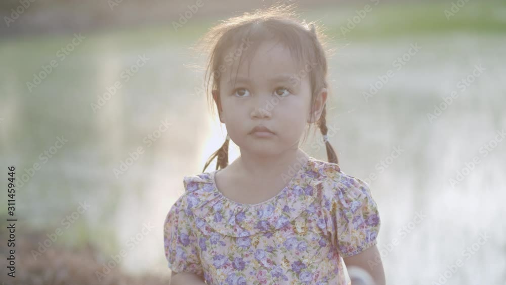 Medium close up of Asian little girl playing with soap bubble blowing in the sunset Medium close up of Asian little girl playing with soap bubble blowing in the sunset