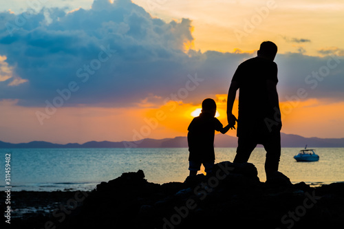 Sylwetka wizerunek ojciec i syn przy plażą
