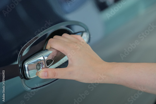 Woman hand on open the new car door