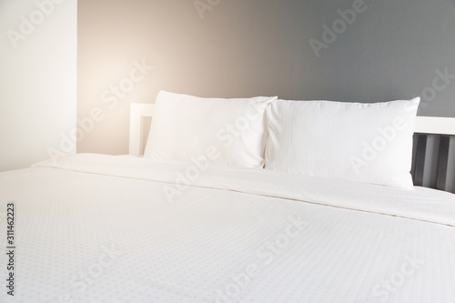 Two white pillow on bed and blanket