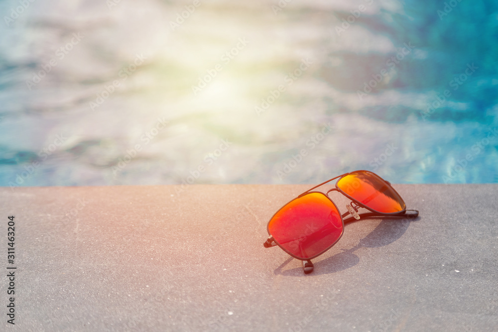 Fashion sun glasses near the swimming pool