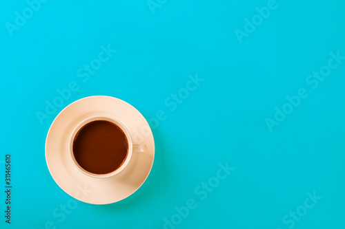 Cup of coffee on blue background .Top view