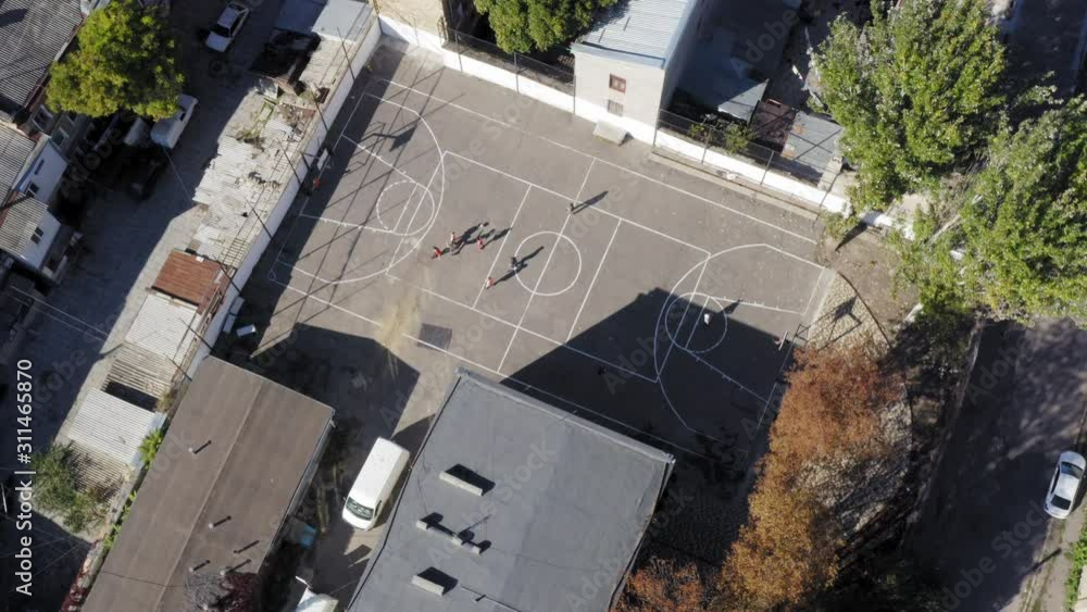 Aerial of group of kids play soccer on asphalt court Odessa Ukraine neighborhood Aerial of group of kids play soccer on asphalt court Odessa Ukraine neighborhood