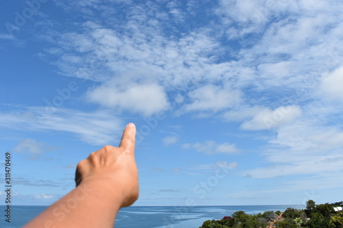 hand pointing to the sky on blue background