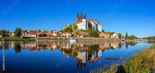 Panoramic view on the Albrechtsburg castle and the Gothic Meissen Cathedral, the embankment and Elbe river on the foreground.