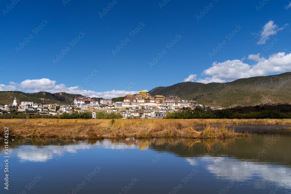 Peaceful landscape background and water reflection of Songzanlin Tibetan Monastery in Shangri-la, Zhongdian, Diqig, China