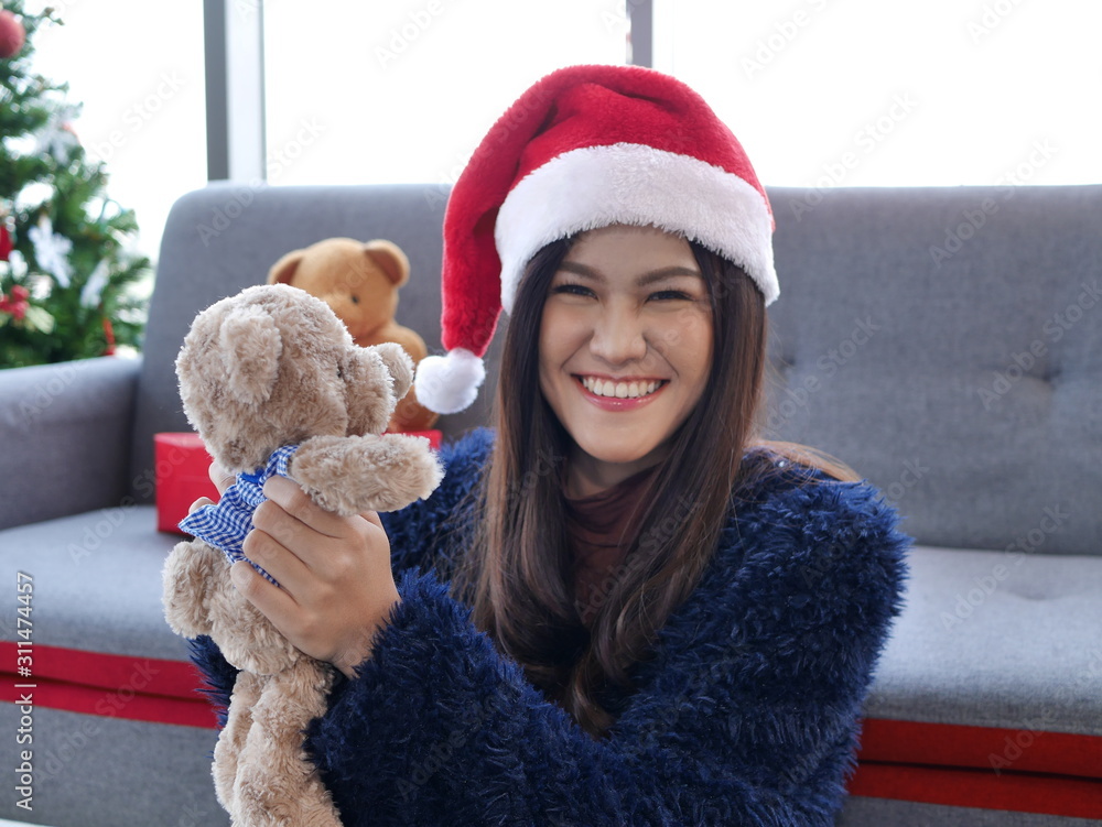Fototapeta premium the young Asian pretty girl relax and surprised at home party for Christmas and new year holding gift during holiday festival