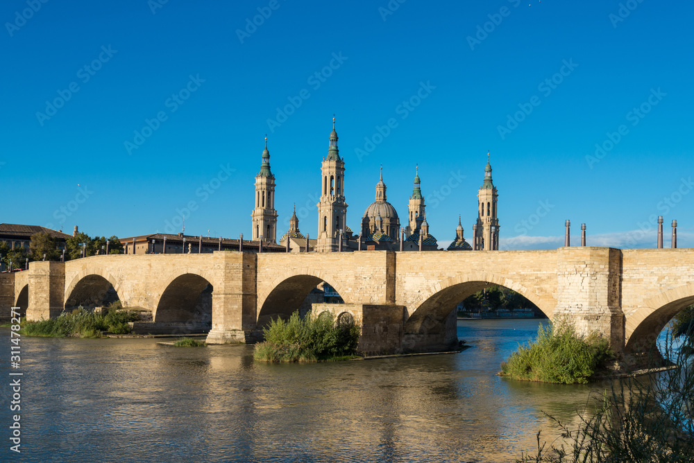 Puente de Piedra bridge across the river Ebro and the ancient church Basilica del Pillar in the Spanish city Zaragoza