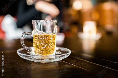 Chamomile tea welcome drinks served in small drinking glass with blur background. Herb drinks.