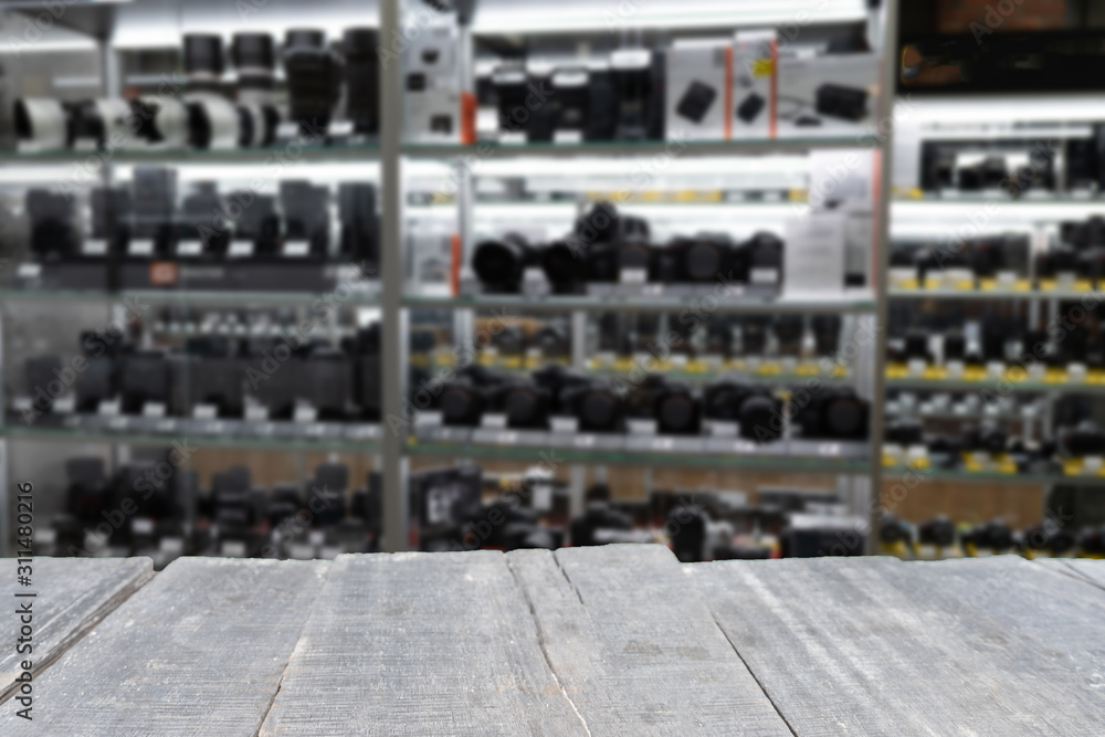 empty wooden table on the background of range of digital mirrorless and SLR cameras and lenses empty wooden table on the background of range of digital mirrorless and SLR cameras and lenses
