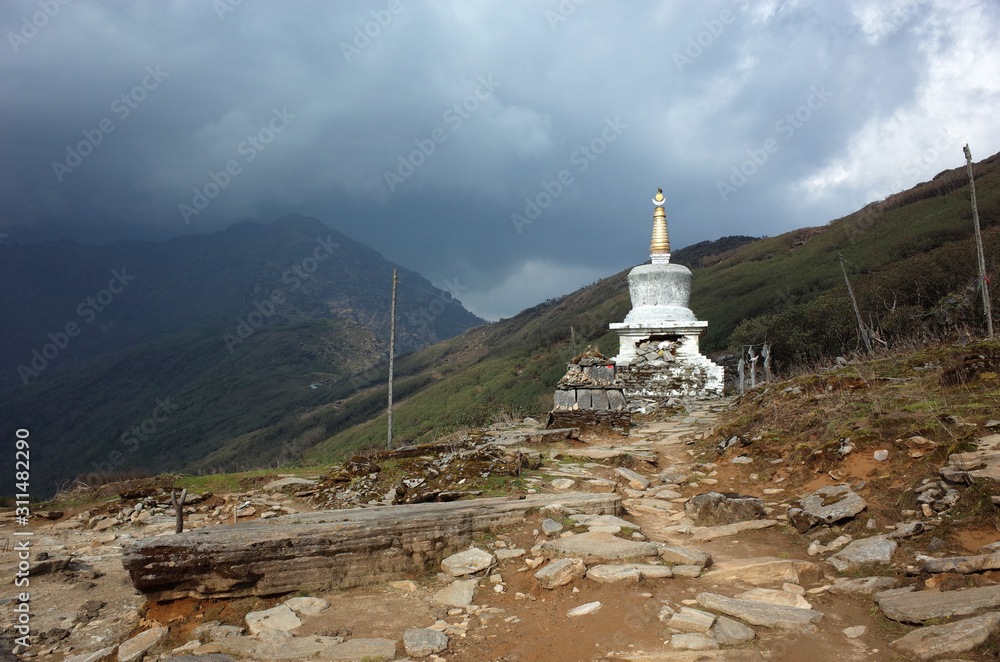 Old white buddhist stupa on Lamjura La pass in Nepal Himalayas, along trail between Jiri and Lukla - lower part of Everest trek