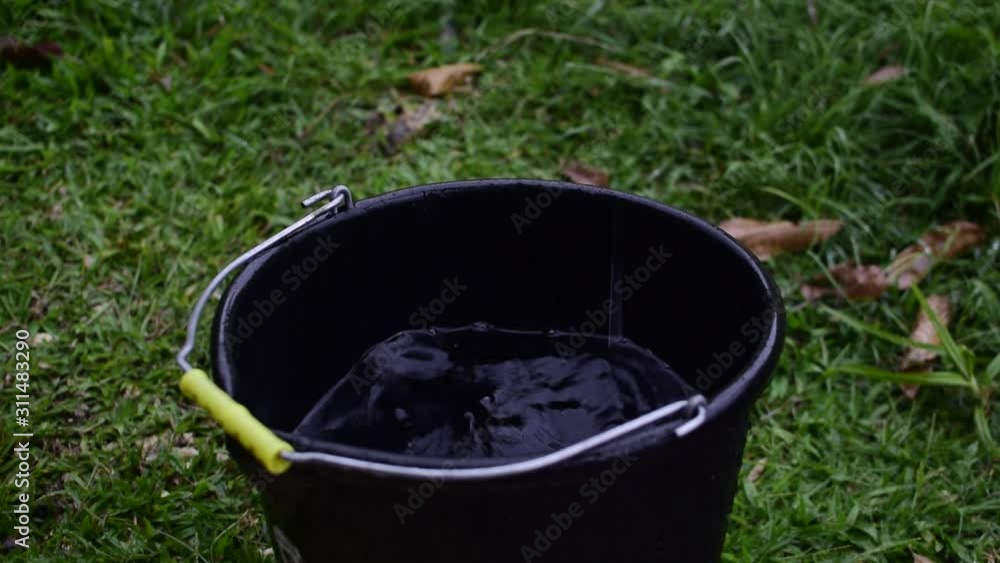 Raindrop in a water bucket on a rainy day Raindrop in a water bucket on a rainy day