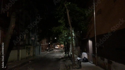 Alley at night in New York City NX Establishing shot man walks in background 4k