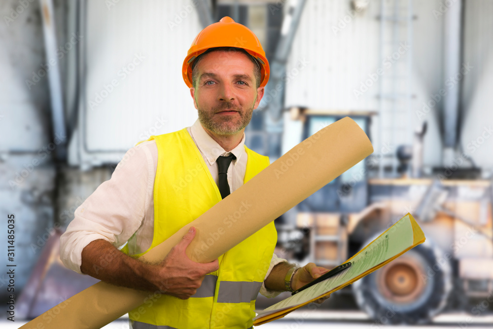 construction work lifestyle portrait of young happy and attractive engineer or building contractor holding blueprints wearing constructor hardhat smiling confident construction work lifestyle portrait of young happy and attractive engineer or building contractor holding blueprints wearing constructor hardhat smiling confident