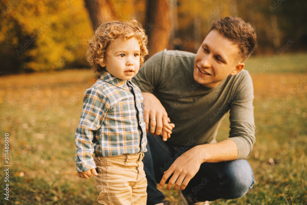 Close up photo of dad with his little boy playing outdoor in park during autumn Close up photo of dad with his little boy playing outdoor in park during autumn