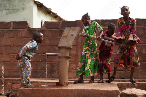 African Children Having Fun At The Water Pump photo
