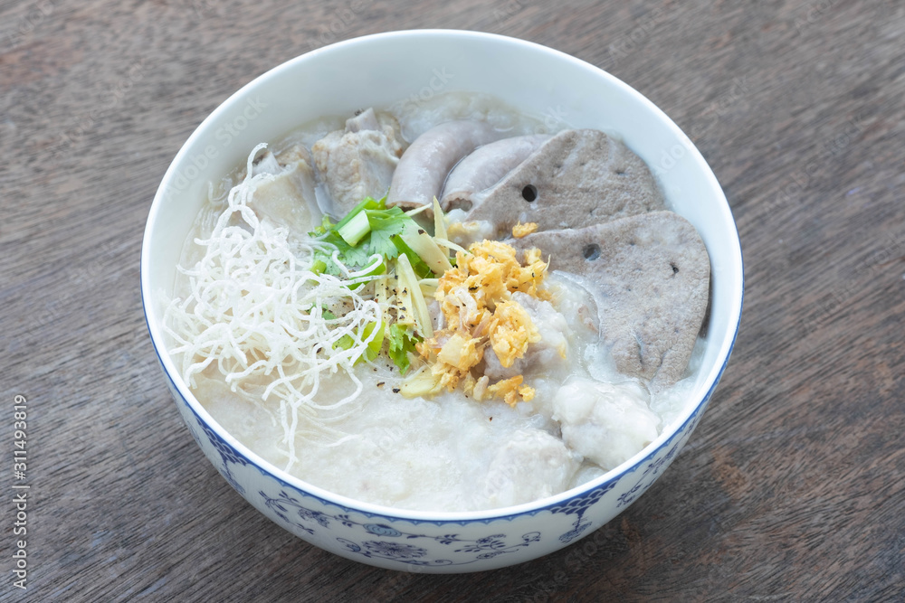 Congee with minced pork, braised pork filling, boiled pork liver, fried garlics minced pork in white bowl. Asian breakfast. Congee with minced pork, braised pork filling, boiled pork liver, fried garlics minced pork in white bowl. Asian breakfast.