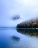 Dolomites Reflection in water in Lago di Braies (Braies lake, Pragser wildsee) South Tyrol, Italy ; Foggy morning high ISO photography