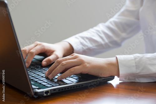 A businesswoman USES a laptop in her office.