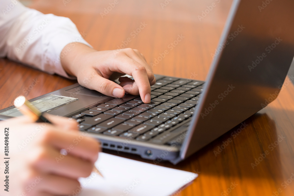 A businesswoman USES a laptop in her office. A businesswoman USES a laptop in her office.
