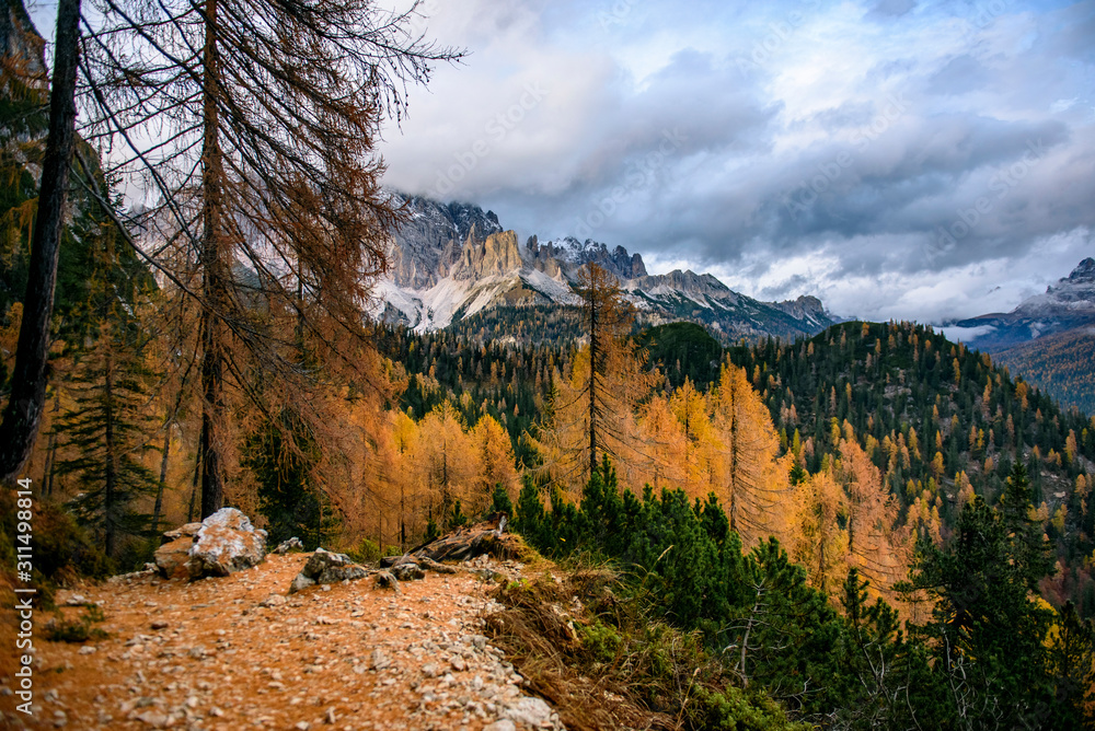 Dolomite mountains surrounded by clouds in South Tyrol, Italy /View from Lago di Sorapis hiking trail, during sunset in Autumn season / High ISO image Dolomite mountains surrounded by clouds in South Tyrol, Italy /View from Lago di Sorapis hiking trail, during sunset in Autumn season / High ISO image