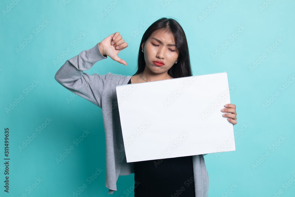 Young Asian woman show thumbs down with white blank sign. Young Asian woman show thumbs down with white blank sign.