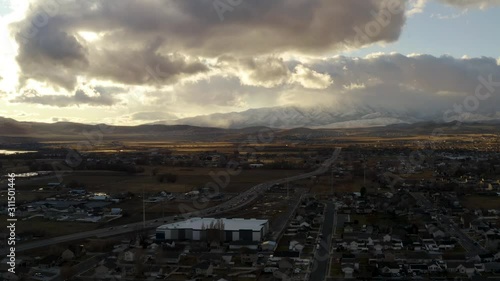 aerial shots over suburban utah with mountains in the background at sunset with traffic photo