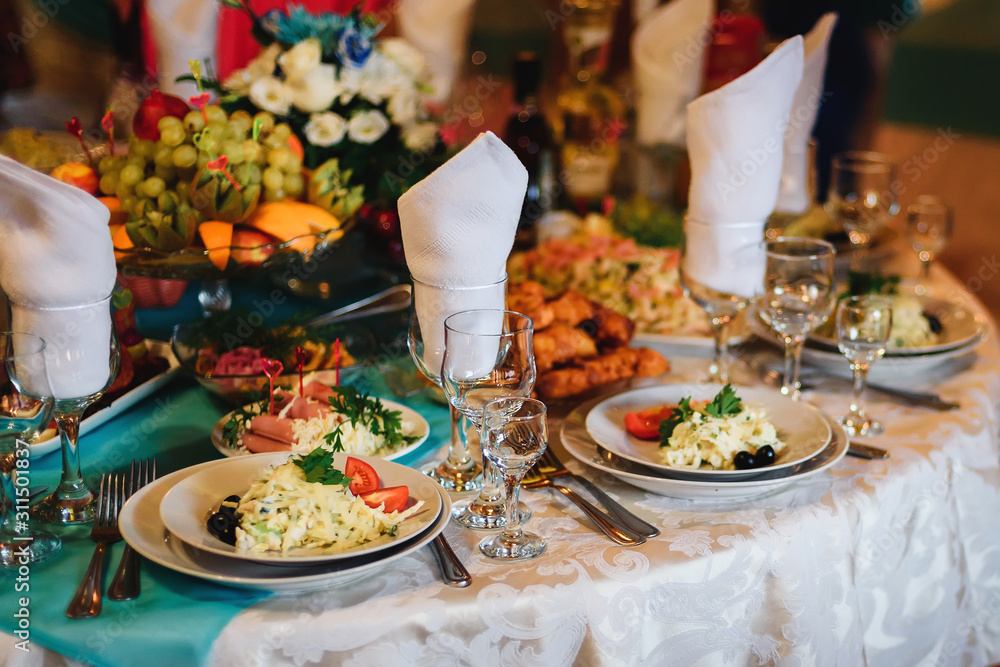 festive table in the restaurant with plates, glasses and Cutlery on a white tablecloth festive table in the restaurant with plates, glasses and Cutlery on a white tablecloth