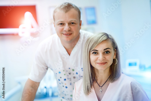 portrait of a team of doctors, man and woman wearing uniform on dentist office background. Stomatology concept