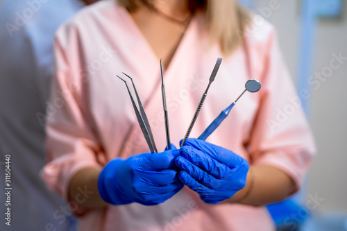 Stomatological instruments in dental clinic. Doctor holding instruments. fan style. Selective focus close up.