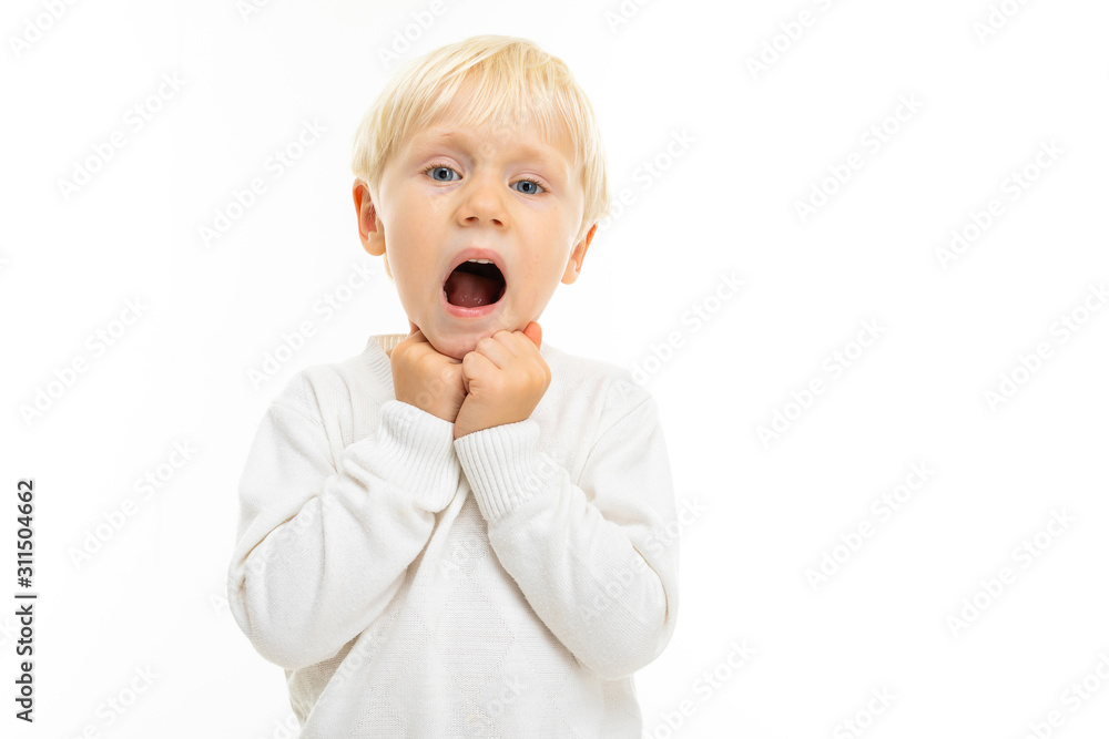 charming blond boy in a white t-shirt shows a grimace on a white background charming blond boy in a white t-shirt shows a grimace on a white background