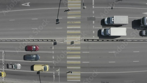 Aerial view of pedestrian crossing road. Cars stop in front of a traffic light. Street with people crossing crosswalk, go on the road. City life. Moscow, Russia.