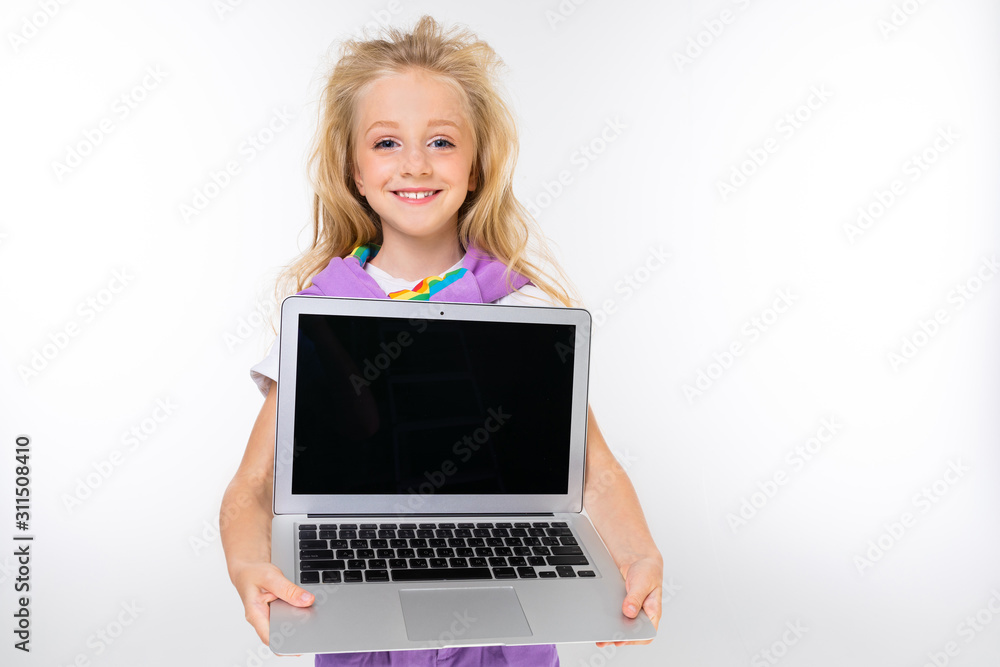 blond child in a casual look shows a laptop display with a mockup on a white background blond child in a casual look shows a laptop display with a mockup on a white background