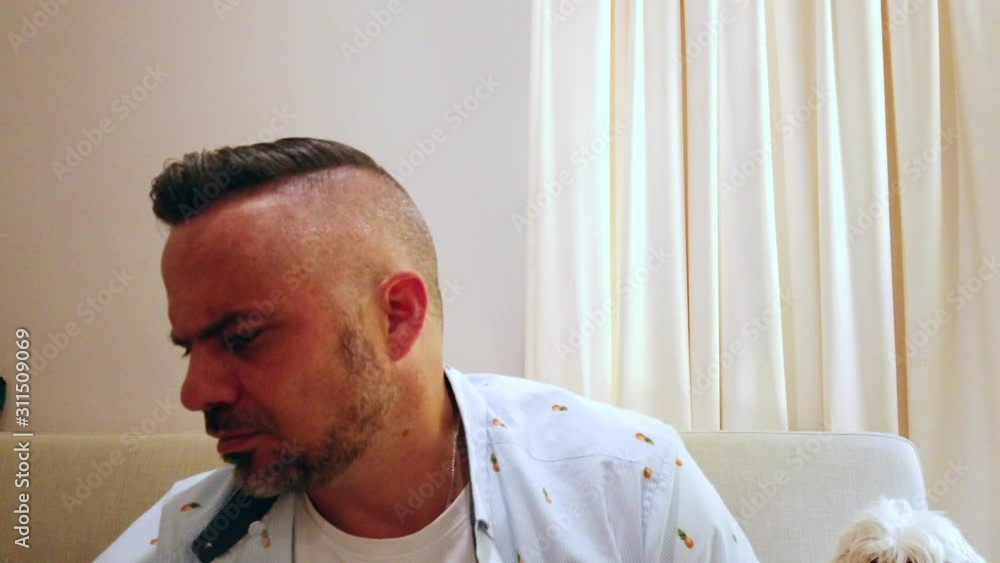 man sitting on the couch making an important decision in slo mo