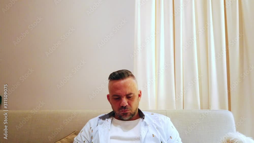 guy sitting on the couch thinking deeply about a decision he needs to make guy sitting on the couch thinking deeply about a decision he needs to make