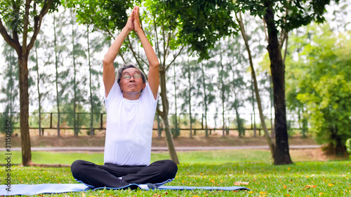 Asian man doing yoga at the park. photo