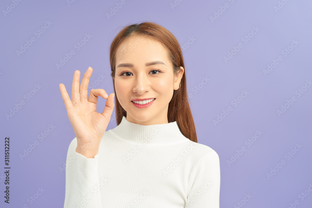 beautiful young girl showing OK sign against violet background beautiful young girl showing OK sign against violet background