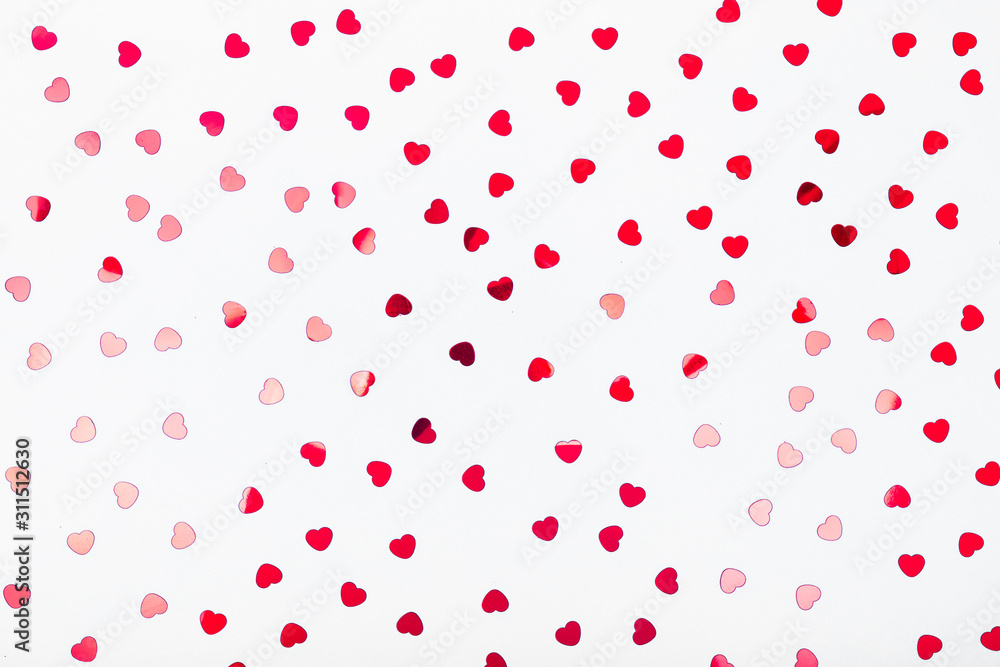 Grey background with red glitter heart confetti. Valentine day concept. Trendy minimalistic flat lay design background. Horizontal