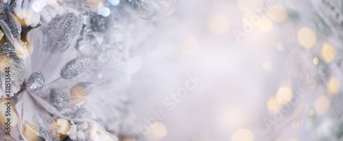 Fototapeta Christmas winter blurred background. Xmas tree with snow decorated with garland lights, holiday festive background. Widescreen backdrop. New year Winter art design, wide screen holiday