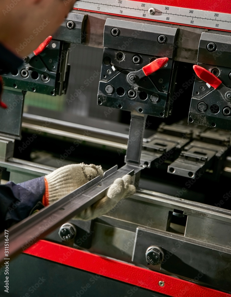 Asian worker using grinder to make heavy machine on assembly line Asian worker using grinder to make heavy machine on assembly line