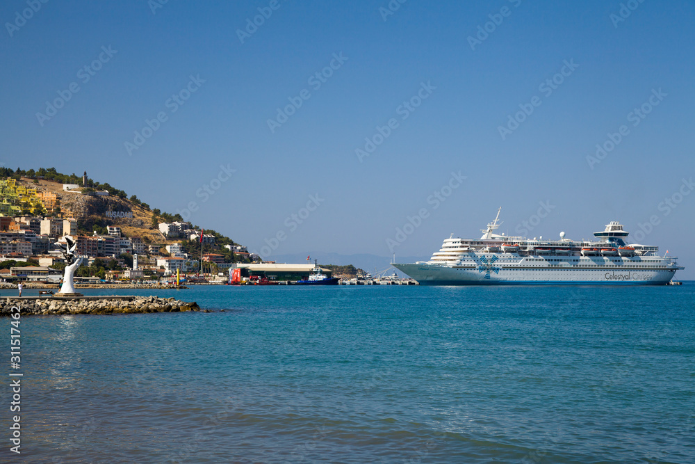 The marina in Kusadasi. The coast and port in the city, fishing boats and tourist ship. Place of holiday photos.