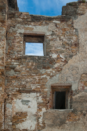 The ancient cobblestone wall with windows close-up. Background of natural stone.