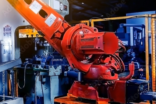 Large factory robot is operating an assembly line job