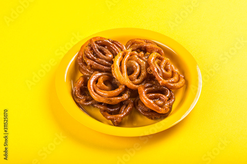 Indian sweet jalebi, indian dessert jalebi or imarti or imarati or jilbi on yellow background photo