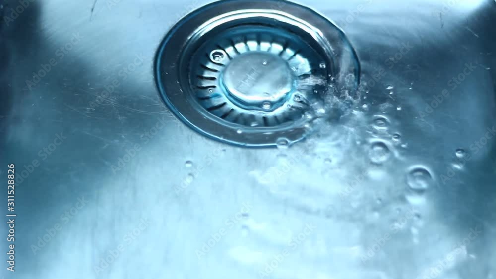 Water in a sink, flowing down, dropping, creating patterns. Water in a sink, flowing down, dropping, creating patterns.