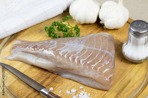 фотографія raw saithe fillet on a cutting board