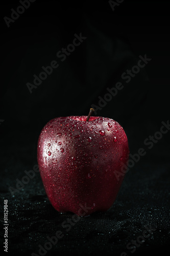 A red apple on a black background.