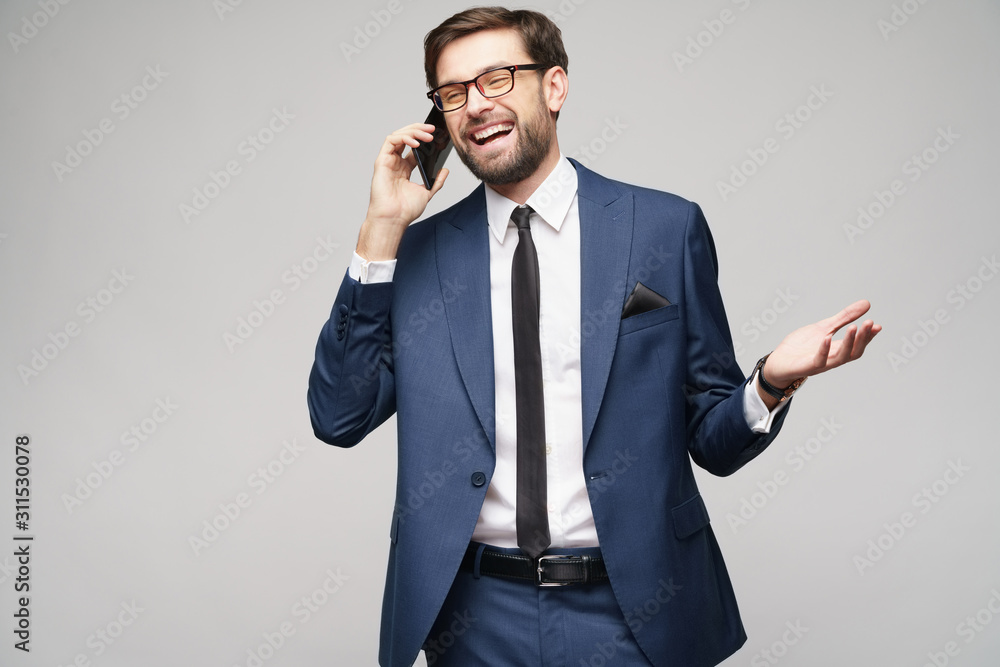 businessman talking on the phone isolated over grey background businessman talking on the phone isolated over grey background